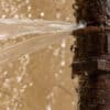Rusty,Burst,Pipe,Spraying,Water,After,Freezing,In,Winter.